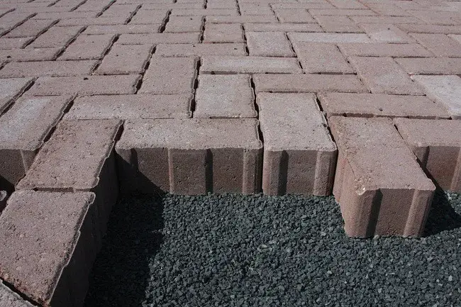 Paver em tom terracota, durante o assentamento sobre brita